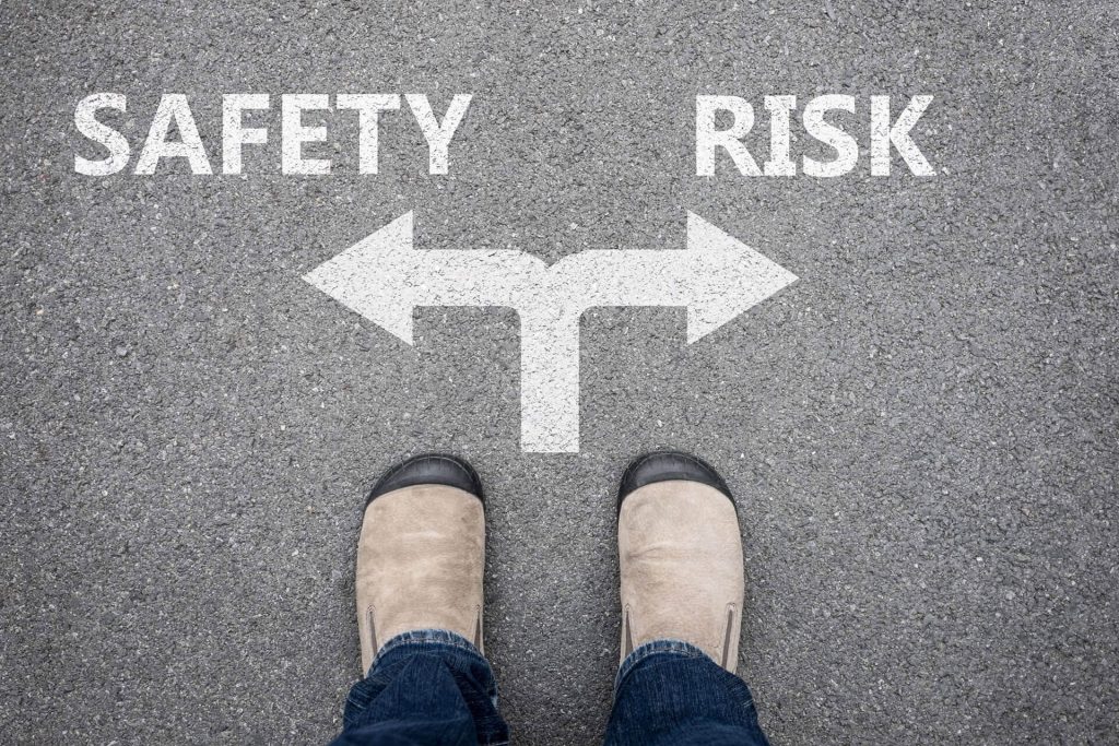 immagine dove si vedono due scarpe con una persona in piedi e due frecce con sinitra scritto safety e a destra risk