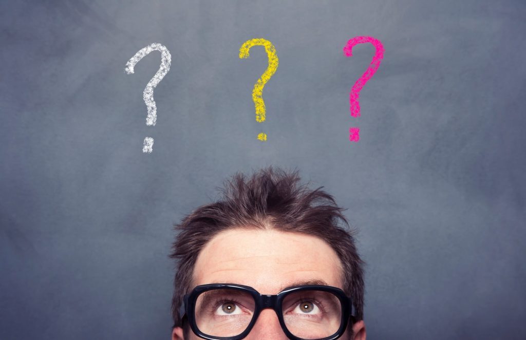 Un uomo con occhiali e un punto interrogativo sopra la testa, che esprime confusione o curiosità.