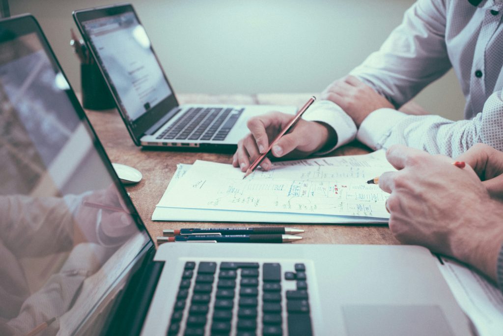 Due professionisti progettano un sistema di stampa aziendale su carta e laptop